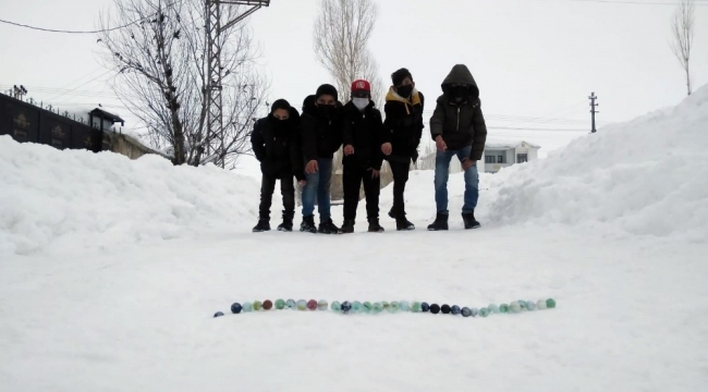 Yüksekova'da çocukların kar üstünde misket keyfi